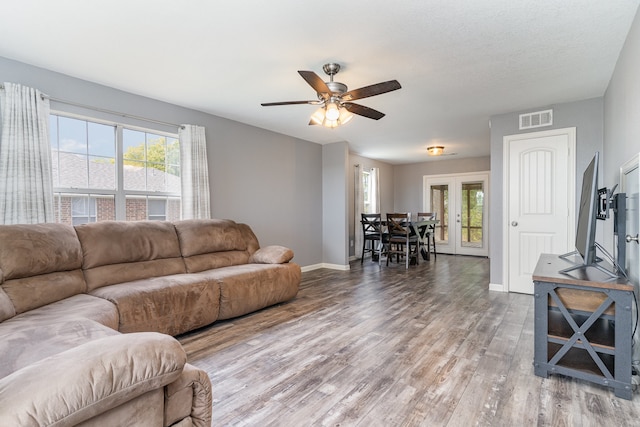 living room with french doors, visible vents, ceiling fan, light wood-type flooring, and baseboards