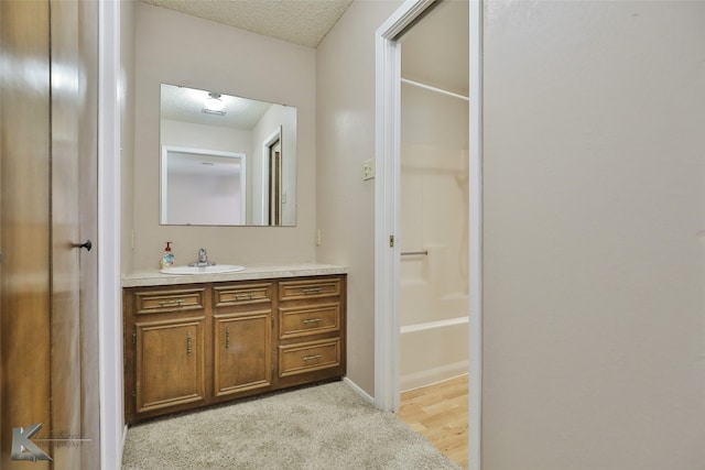 bathroom with vanity, a textured ceiling, hardwood / wood-style flooring, and independent shower and bath