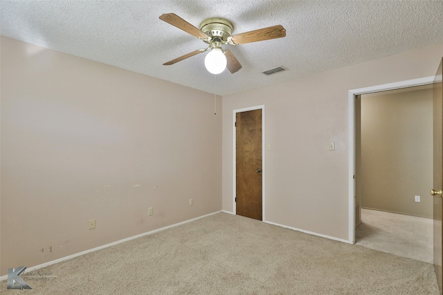 unfurnished bedroom featuring light carpet, a textured ceiling, and ceiling fan