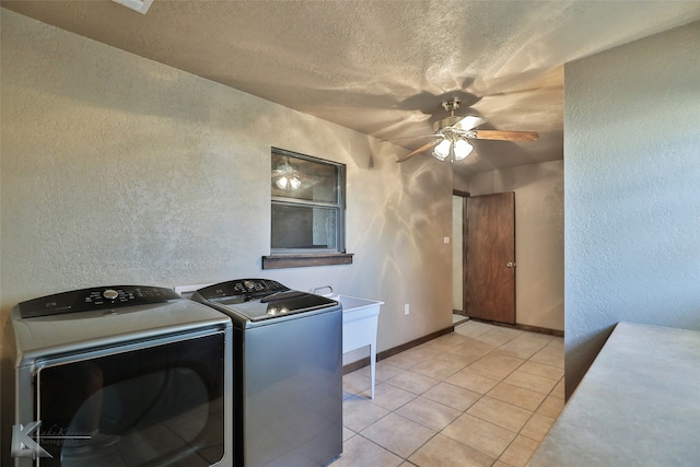 washroom with ceiling fan, a textured ceiling, washing machine and dryer, and light tile patterned floors