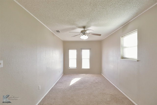 empty room featuring ceiling fan, a textured ceiling, and light colored carpet