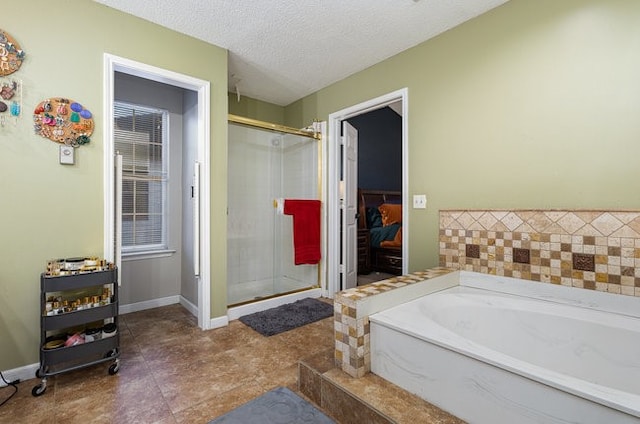 bathroom with tile patterned flooring, a textured ceiling, and separate shower and tub