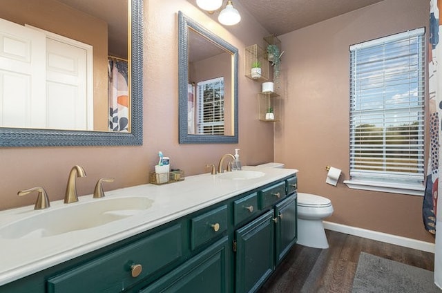 bathroom featuring toilet, vanity, wood-type flooring, and a textured ceiling