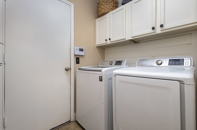 clothes washing area featuring cabinets and independent washer and dryer