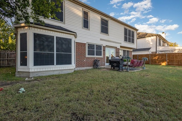 rear view of property featuring a patio and a yard