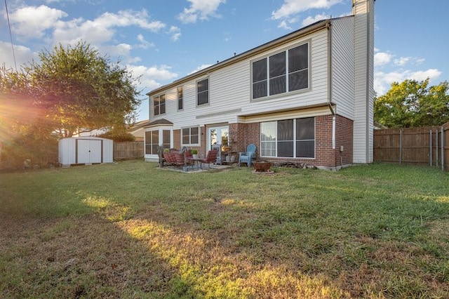 rear view of property with a patio, a yard, and a storage shed