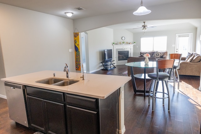 kitchen featuring a kitchen island with sink, dishwasher, dark hardwood / wood-style floors, decorative light fixtures, and sink