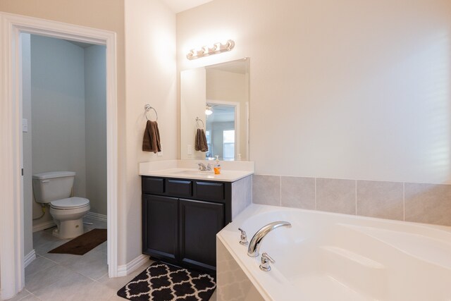 bathroom featuring vanity, toilet, tiled bath, and tile patterned floors