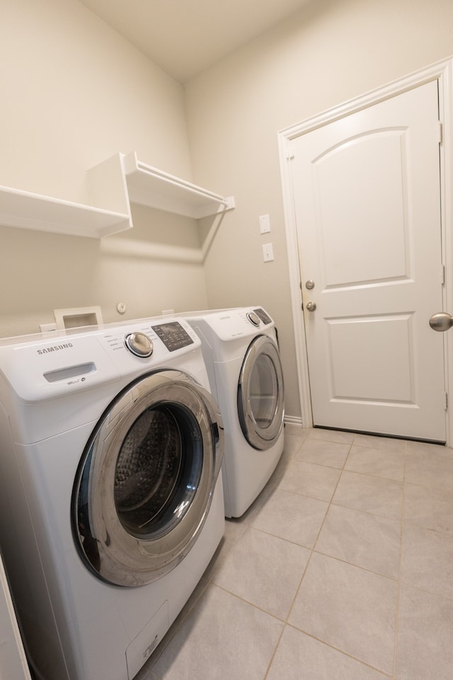 washroom with washer and dryer and light tile patterned floors