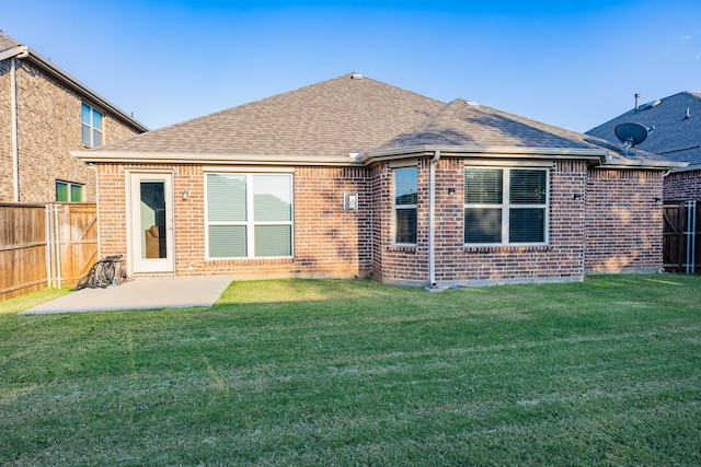 rear view of property with a patio and a lawn