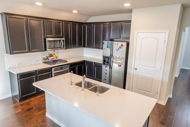 kitchen featuring decorative backsplash, appliances with stainless steel finishes, a kitchen island with sink, dark hardwood / wood-style floors, and sink