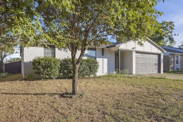 ranch-style home with a front lawn and a garage