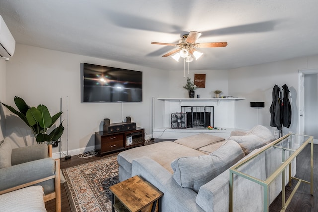 living room featuring an AC wall unit, hardwood / wood-style flooring, a tiled fireplace, and ceiling fan