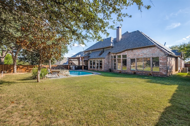 back of property featuring a fenced in pool, a patio area, a yard, and cooling unit