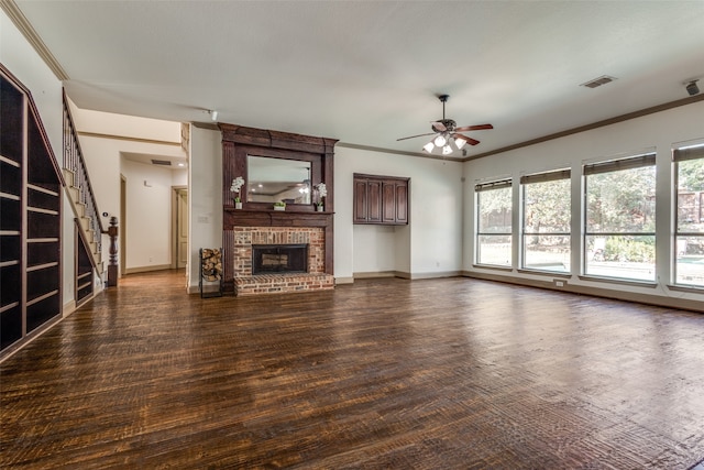 unfurnished living room featuring dark wood-type flooring, ceiling fan, a healthy amount of sunlight, and a brick fireplace