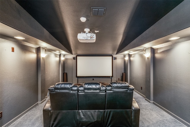 home theater featuring a textured ceiling, lofted ceiling, and carpet floors