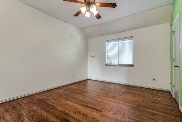 spare room featuring dark wood-type flooring, ceiling fan, and vaulted ceiling