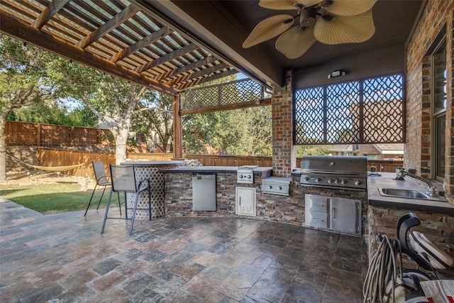 view of patio / terrace featuring exterior kitchen, ceiling fan, a wet bar, a pergola, and a grill