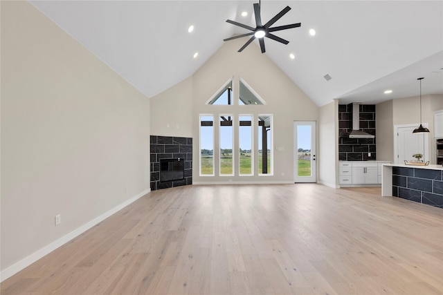 1230 Dixie Estates Way, Whitesboro, TX 76273 - unfurnished living room with high vaulted ceiling, a tiled fireplace, ceiling fan, light wood-style floors, and baseboards