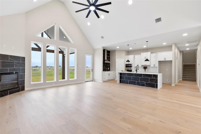 1230 Dixie Estates Way, Whitesboro, TX 76273 - unfurnished living room with a high end fireplace, ceiling fan, high vaulted ceiling, light wood finished floors, and recessed lighting