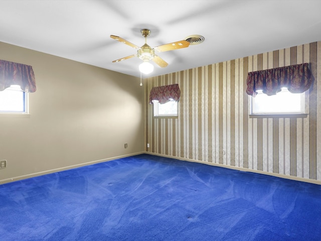 unfurnished room featuring ceiling fan, carpet flooring, and a wealth of natural light