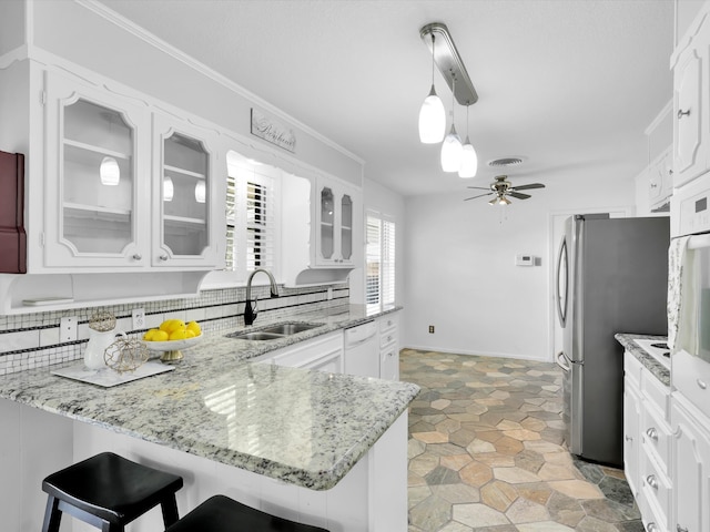 kitchen with kitchen peninsula, white cabinetry, sink, and hanging light fixtures