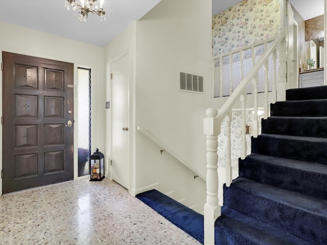 foyer entrance with a notable chandelier