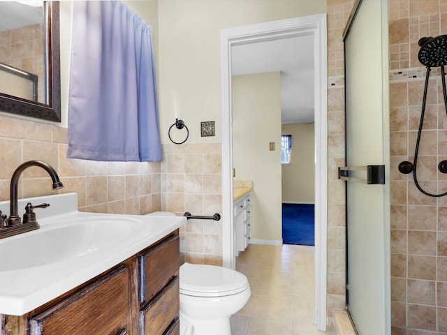 bathroom featuring tile walls, toilet, vanity, an enclosed shower, and tile patterned flooring