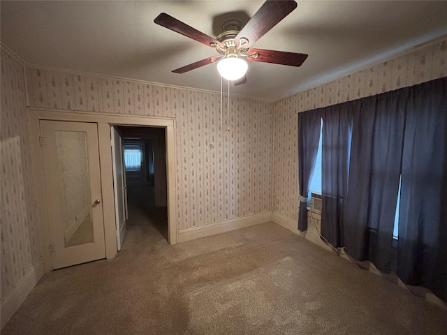 carpeted spare room with ceiling fan and crown molding