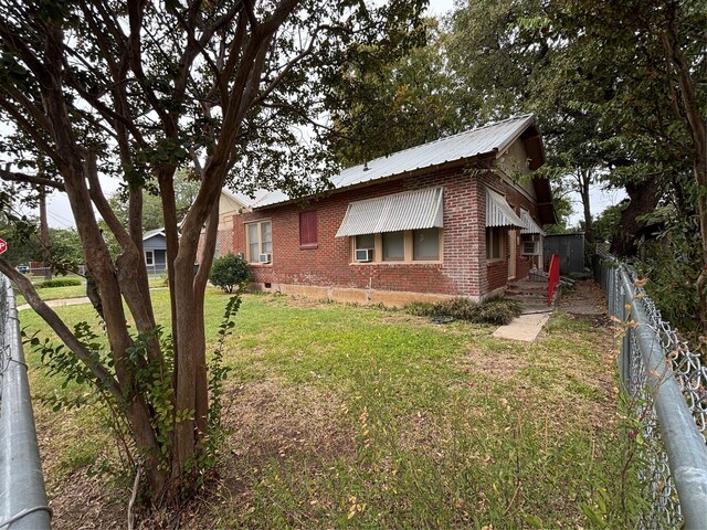 view of home's exterior with cooling unit and a lawn