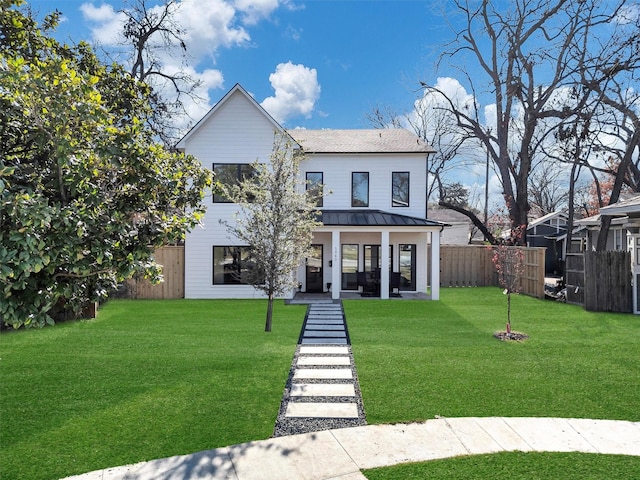 modern inspired farmhouse with a front lawn and covered porch