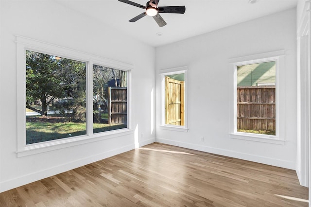 unfurnished room with plenty of natural light, ceiling fan, and light wood-type flooring