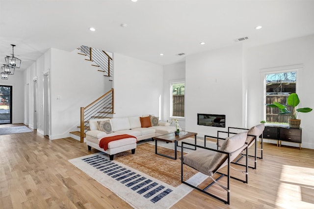 living room featuring an inviting chandelier and light hardwood / wood-style flooring