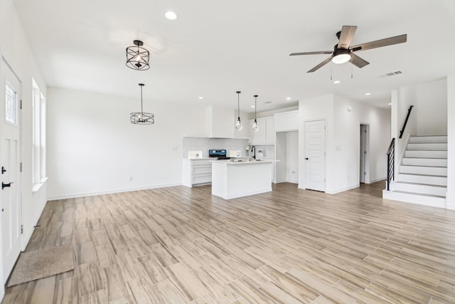 1610 Life Ave, Dallas, TX 75212 - unfurnished living room with stairway, light wood finished floors, a ceiling fan, baseboards, and recessed lighting