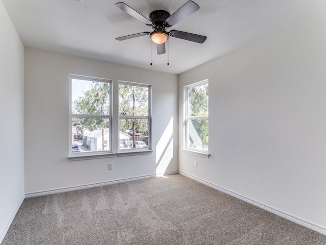 carpeted spare room featuring ceiling fan