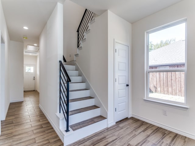 stairway with hardwood / wood-style flooring and a healthy amount of sunlight