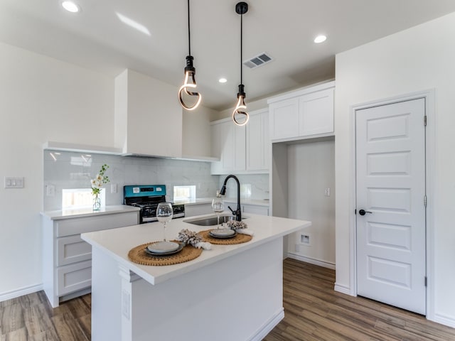 kitchen with range, a kitchen island with sink, sink, and dark wood-type flooring