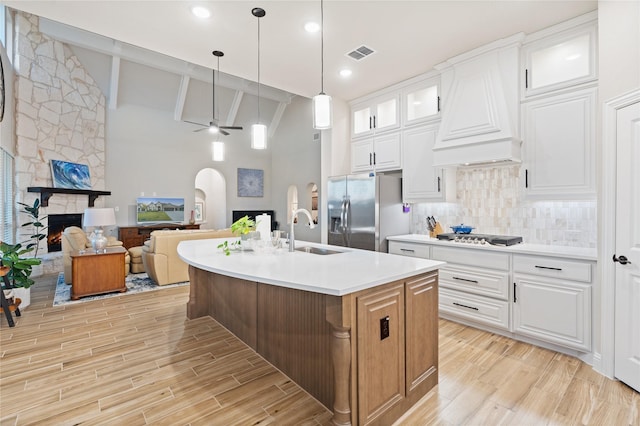 kitchen with white cabinetry, sink, stainless steel appliances, and a center island with sink