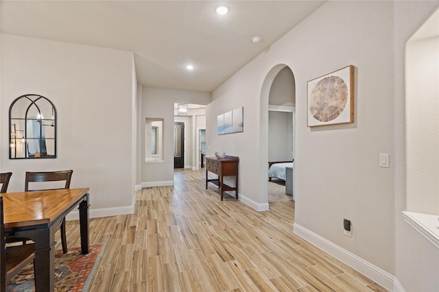 hall featuring an inviting chandelier and light hardwood / wood-style flooring