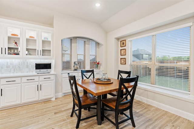 dining space featuring lofted ceiling and light wood-type flooring