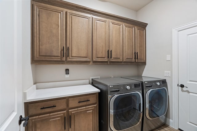 laundry area featuring washer and clothes dryer and cabinets