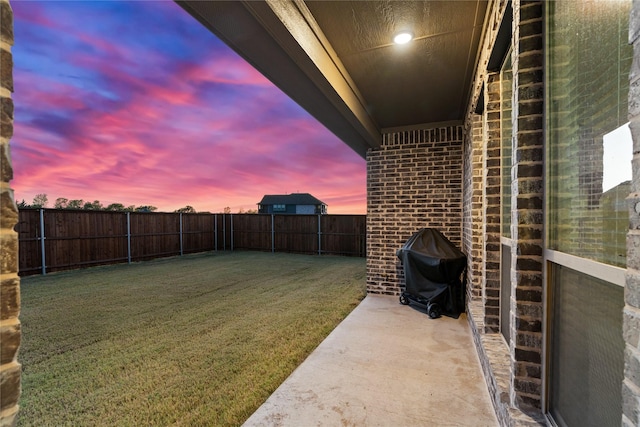 yard at dusk featuring a patio