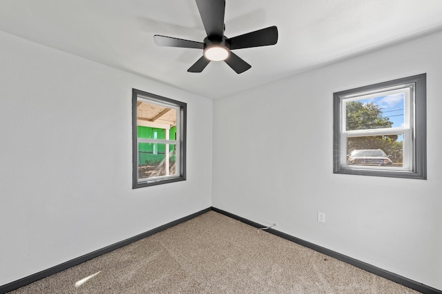 carpeted empty room featuring a healthy amount of sunlight and ceiling fan