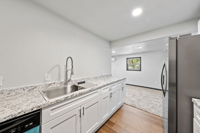 kitchen featuring dishwasher, sink, white cabinets, stainless steel fridge, and light stone counters