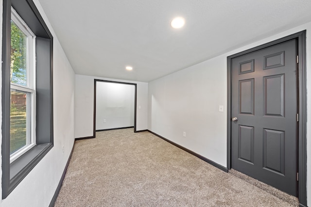 unfurnished room featuring light colored carpet