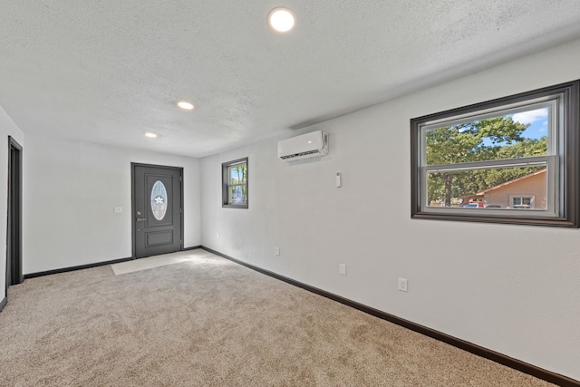 carpeted foyer with a textured ceiling and an AC wall unit