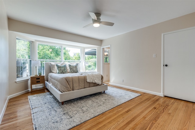 bedroom featuring multiple windows, light wood-type flooring, and ceiling fan