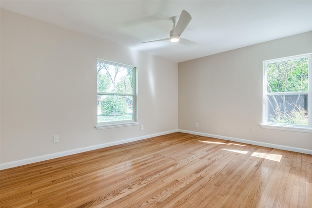 unfurnished room with baseboards, a healthy amount of sunlight, light wood-style floors, and a ceiling fan