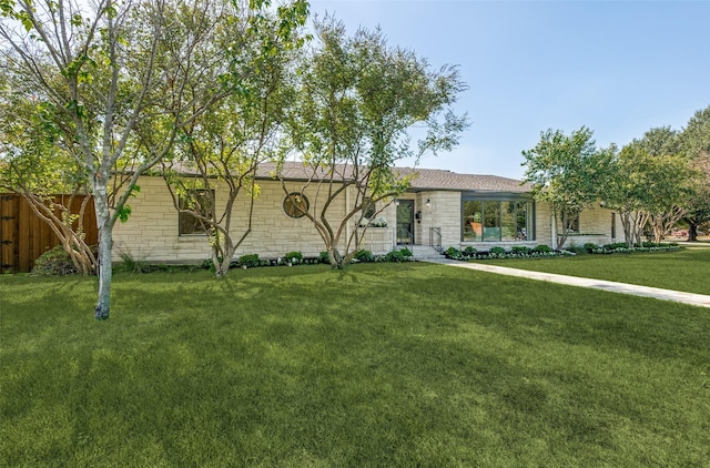 ranch-style home with fence and a front yard