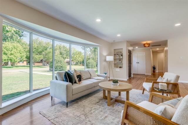 living room featuring visible vents, baseboards, light wood-style floors, and recessed lighting